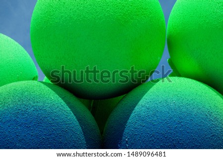 Green and blue balls balloons on cloud sky background. Macro close up image. Vivid holiday poster with copy space. Sunny happy day concept
