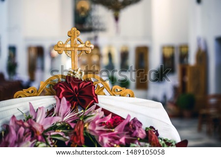 Small cross with flower decoration inside of a church