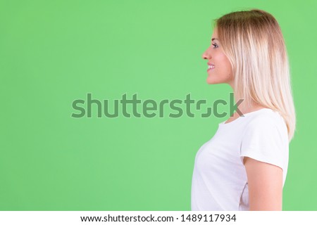 Profile view of happy young beautiful blonde woman smiling