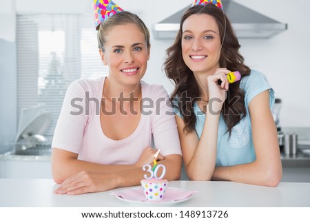 Beautiful women celebrating birthday and wearing party hats