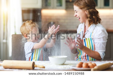 happy family in the kitchen. mother and  child son preparing the dough, bake cookies
