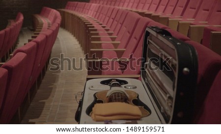 Close-up photo of rows of red seats in the cinema. violin