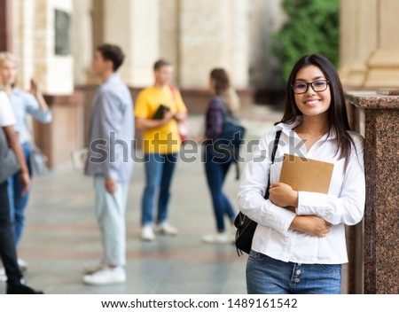 University life. Happy asian girl holding books and smiling, resting between classes Royalty-Free Stock Photo #1489161542
