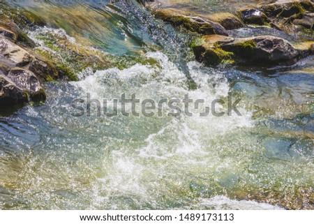 Stormy stream of water near pebbles in a mountain river