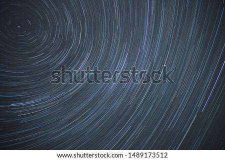 Astro photography time lapse of star trails rotating around the north polar star showing the rotation of earth