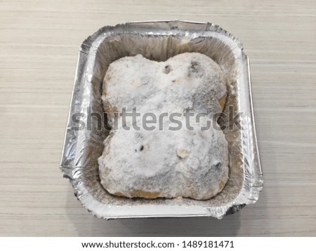 Chocolate Snow Bread Fresh butter in foil tray on wood grain table