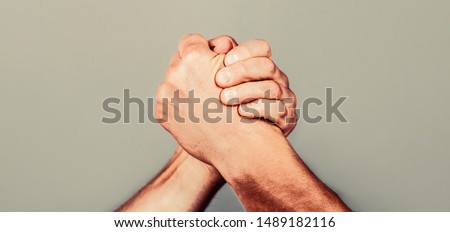 Arms wrestling. Friendly handshake, friends greeting, teamwork, friendship. Handshake, arms, friendship Man hand Two men arm wrestling