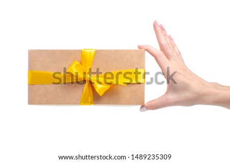 Box with yellow ribbon bow gift in hand on white background isolation