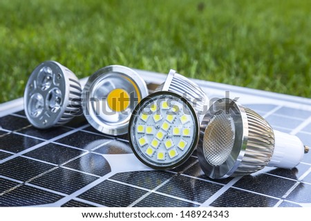 various GU10 LED bulbs on photovoltaics in the grass E27 LED and CFL  bulbs Royalty-Free Stock Photo #148924343
