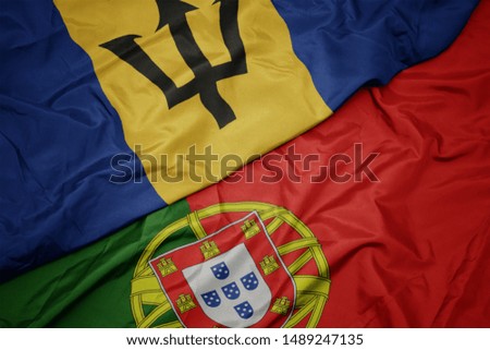 waving colorful flag of portugal and national flag of barbados. macro