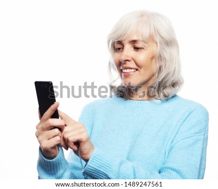 Lifestyle, tehnology and people concept: eldery woman with smartphone
