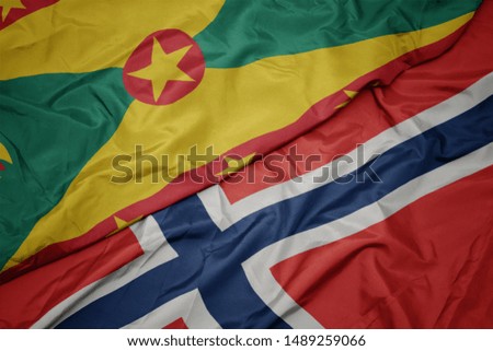 waving colorful flag of norway and national flag of grenada. macro