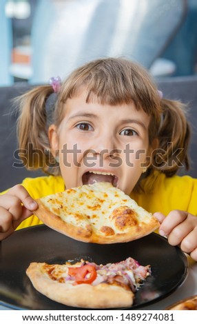 The child eats cheese pizza. Selective focus.