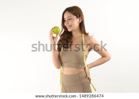 Pretty asian woman with apple and measure tape on white background.