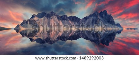 Scenic image of famous Stokksnes cape and Vestrahorn Mountain with ideal reflections and colorful dramatic sky during sunset in Iceland. Iconic location for landscape photographers. Amazing nature  Royalty-Free Stock Photo #1489292003