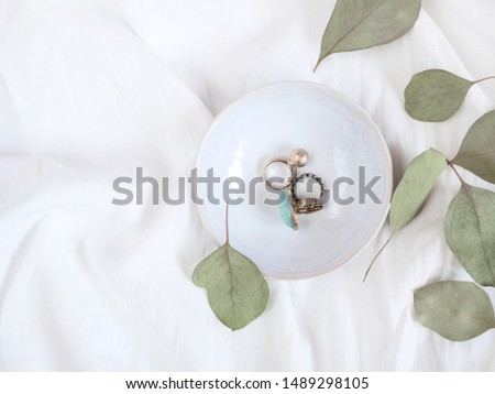 Woman's jewelry decorated with eucalyptus leaves isolated on textured white background. Flat lay. Top view. Copy space