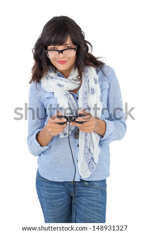 Young woman wearing scarf and glasses playing video games on white background