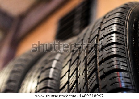 close up of black tires lined up with bokeh background in a shop 