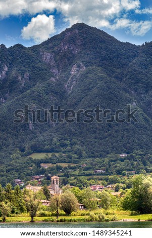 Amazing view landscape on beatiful Lake Idro in Brescia Province, Lombardy, Italy. Scenic small town with traditional houses and clear blue water. Summer vacation for tourists on rich resort in Italy.