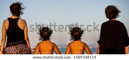 Grandmother, mother and daughter twins walking on sand. Three different generation conceptual picture.