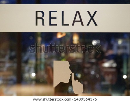                                the word relax on the glass door with the sign bellow