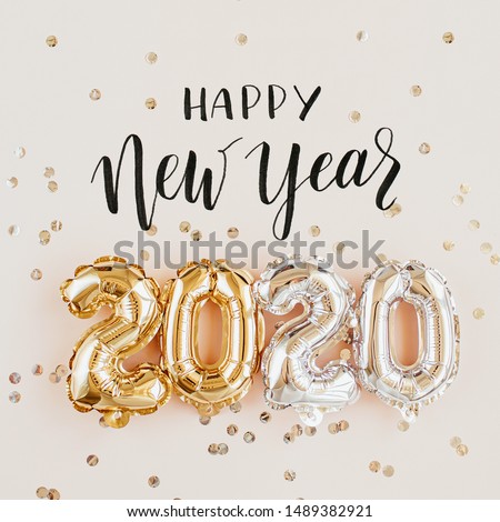 Happy New year 2020 celebration. Gold and silver foil balloons numeral 2020 and confetti on pink background. Flat lay Royalty-Free Stock Photo #1489382921