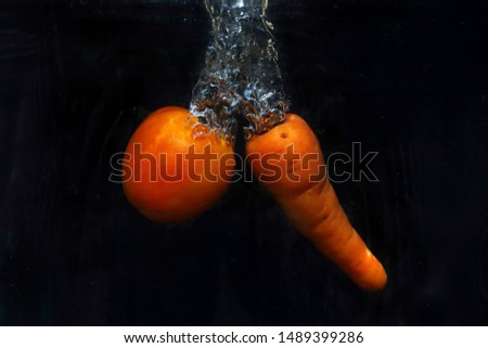 tomato and carrot splashing in the water