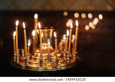 Golden candles light in the russian orthodox church. Holiday background. Selective focus.