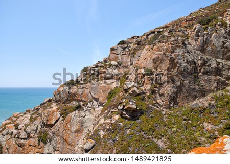 Cape ROCA is the westernmost Cape of Eurasian continent, located on territory of Portugal. Beautiful picture of ocean, hilly terrain, rocks, waves, sky. Famous tourist spot