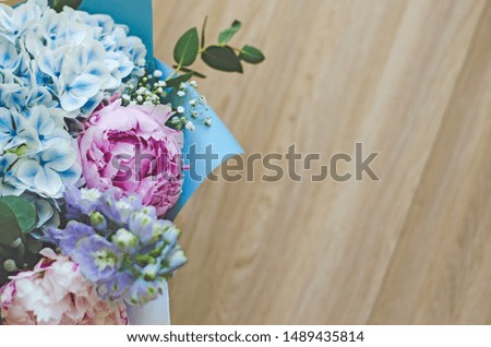 Bouquet of flowers close-up. The view from the top. Standing on the floor, tree. Summer flowers. Peonies, hydrangea and others. Soft focus.