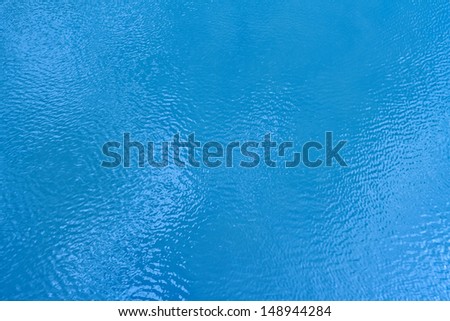 White clouds reflecting in the moving blue water.