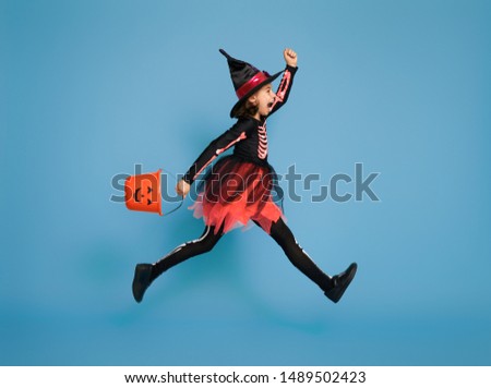 Happy Halloween! Cute little witch with a pumpkin on blue background.                                  
