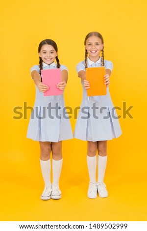 School library. Homeschooling concept. Literacy club. Cute children holding books on yellow background. Little girls with encyclopedia or childrens books. Educational books for schools. Reading books.