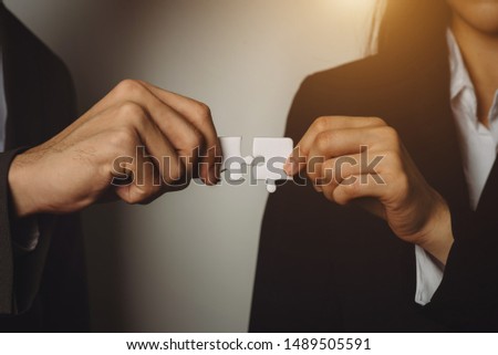Business solutions and success concept. Businessman hand connecting jigsaw puzzle at office in morning light
