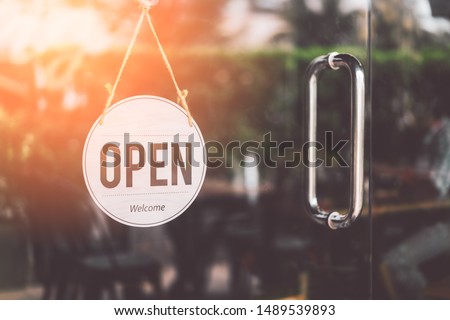 Open sign hanging front of cafe with colorful bokeh light abstract background. Business service and food concept. Vintage tone filter effect color style.