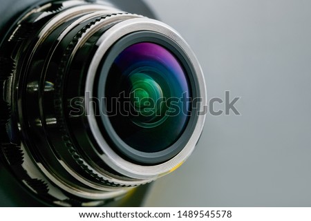 Camera lens with gray backlight. Side view of the lens of camera on gray background. Gray camera Lens close Up.