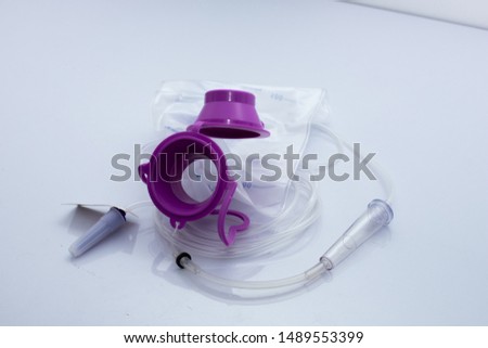 Feeding Pump medical device purple color to supplement nutrition liquid food to tube Enteral feeding fluid set bag with clamp, single use only Royalty-Free Stock Photo #1489553399