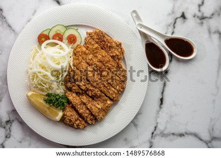 Pork tonkatsu served with lettuce And delicious gravy Is a national food that is good for health, Pork tonkatsu