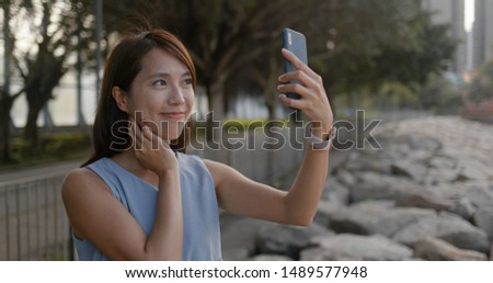 Woman take selfie on cellphone at outdoor