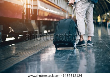 Asian man is traveler, he is waiting for their train. Outdoor adventure travel by train concept. Bangkok, Thailand. Happy/positive/healthy hike/travel/wanderlust concept Royalty-Free Stock Photo #1489612124