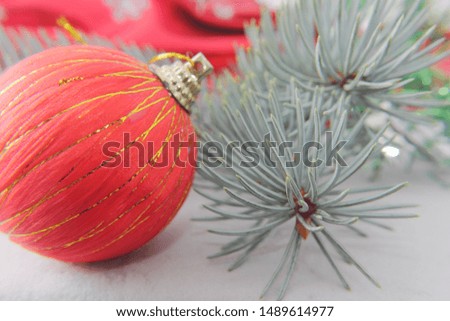 Colors of Christmas and New Year mood. Santa hat, Christmas tree and juniper branches among bright colored Christmas-tree decorations: balls and hearts.