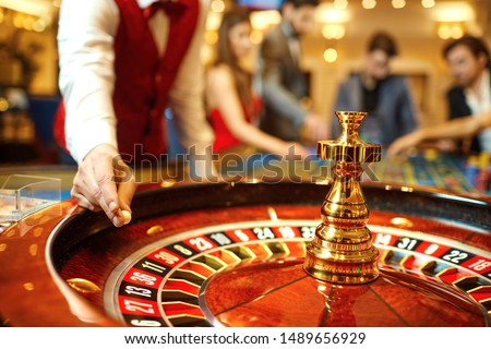The croupier holds a roulette ball in a casino in his hand. Royalty-Free Stock Photo #1489656929