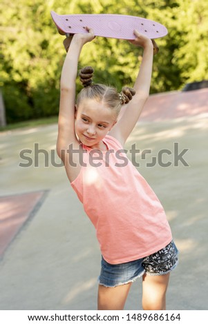 Girl holding skateboard over head