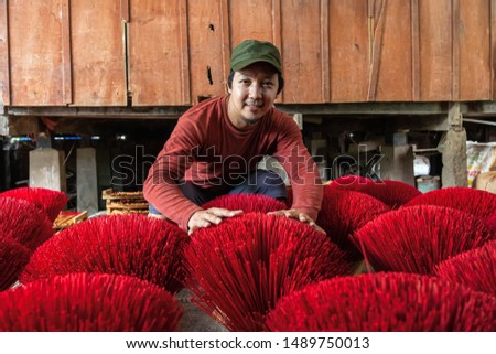 Asian traveler male making the traditional vietnam red insense in old traditional house at long xuyen, an giang province, vietnam,traditional and culture concept