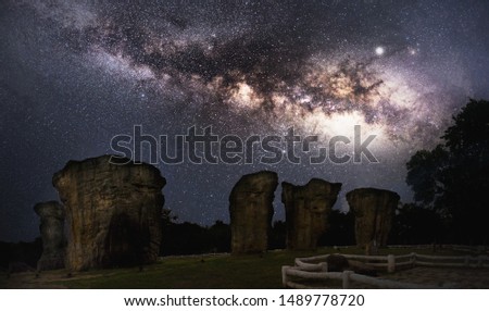 Milky way galaxy on hill under amazing starry blue night sky. Silhouette of Mor Hin Khao, The Stonehenge of Thailand aged 175 million years Jurassic-Cretaceous at Phu Lan Kha National Park, Chaiyaphum
