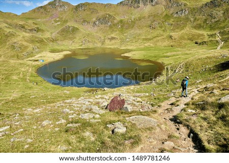 mountaineers and tents on the high mountain lake called Ibón de Escalar in the Pyrenees
