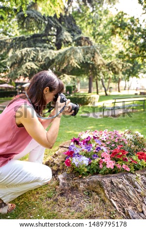 view of a woman photographing a beautiful flowers