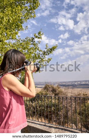 view of a woman photographing a beautiful landscape