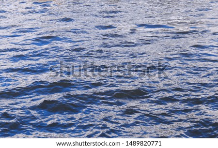 Water surface horizontal blue texture with waves and ripples, natural environmental background. Vibrant blue sea water with empty copy space