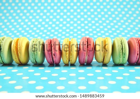 french colorful dessert Cake macaron on retro pastel green background with white polka dots. macaroon on turquoise background with dots. colorful almond cookies, pastel colors, vintage card